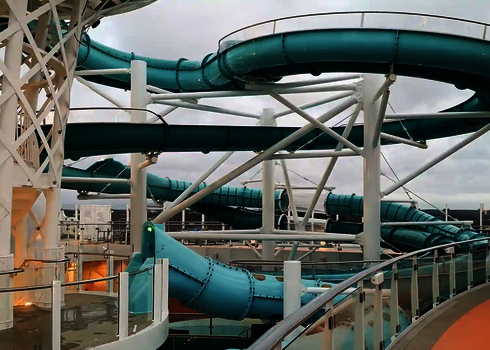 Große, kurvige 2-in-1 Racer Wasserrutsche mit transparenten Abschnitten auf einem Kreuzfahrtschiff.