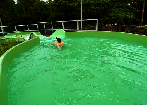 Blick auf das Auslaufbecken des Wildwasserflusses mit Person in Rückenlage.