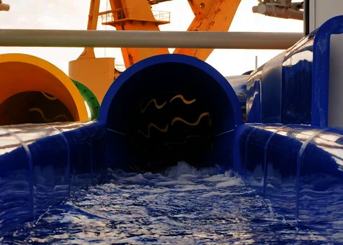 Zugang zu drei farbigen Wasserrutschen RR900 mit sprudelndem Wasser im Auslauf.