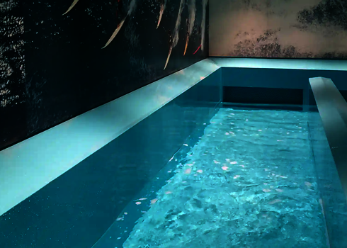 Peaceful view of the turquoise-coloured catch basin with wall graphics of surfers.