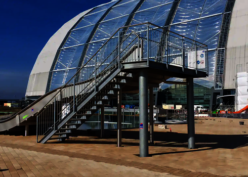 Eine Breitwellenrutsche mit Treppenaufgang vor einer Kuppel.