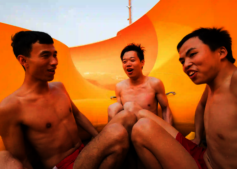 Drei junge Männer fahren im gelben Rundreifen durch den leuchtend gelben Trichter der RR2700.