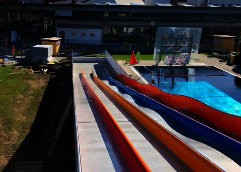 Blick entlang der bunten Multilane im Freibad auf das Wasserbecken.