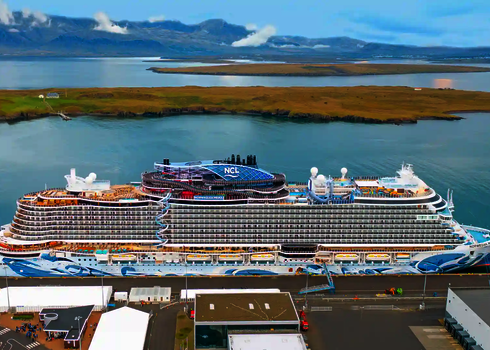 Norwegian Prima Kreuzfahrtschiff mit Wasserpark und Lotus Reifenrutsche im Hafen.