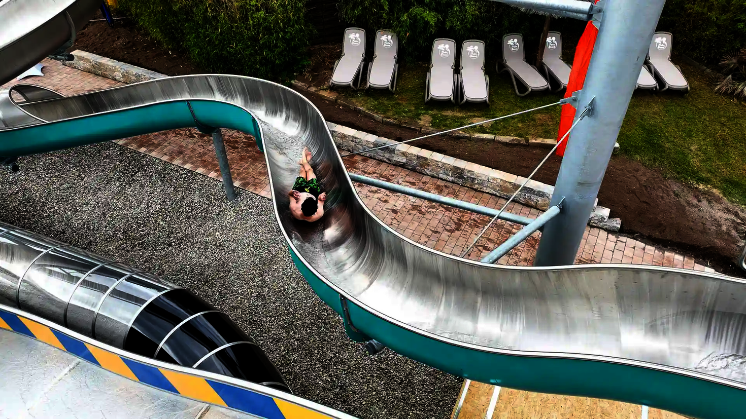 Person rutscht eine lackierte WR800 Edelstahlrutsche hinunter.