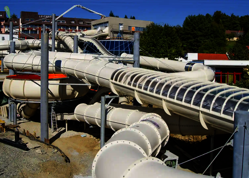 Raft Racer Röhrenrutsche im Bau, mit mehreren Stützen und transparenten Elementen.