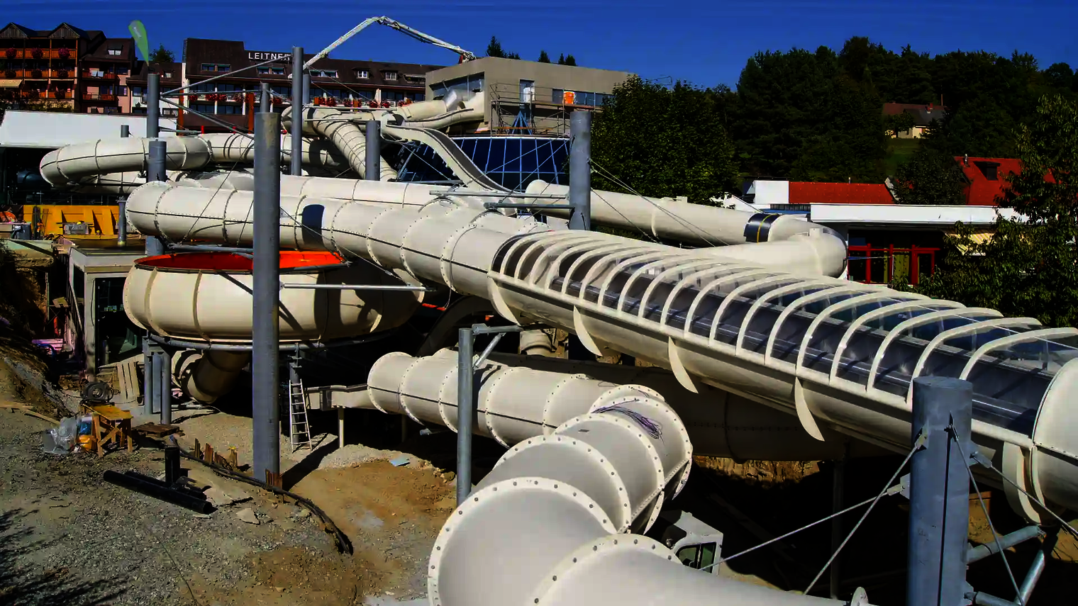 Raft Racer Röhrenrutsche im Bau, mit mehreren Stützen und transparenten Elementen.
