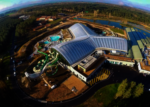 Luftaufnahme des gesamten Wasserparks mit deutlich sichtbarer Boomerang-Rutsche.