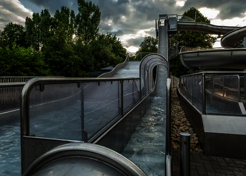 Freifallrutsche im Innenbereich mit senkrechtem Verlauf über ein Wasserbecken.