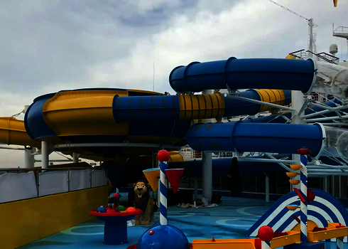 Eine blau gelbe RR1200 Wasserrutsche hinter dem Kinderspielbereich auf einem Kreuzfahrtschiff.