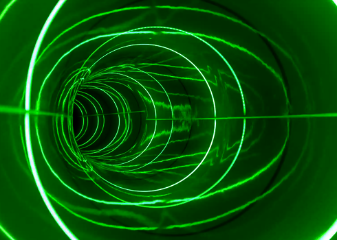 Innenansicht einer grün beleuchteten Röhrenrutsche mit ringförmigen LED-Effekten.