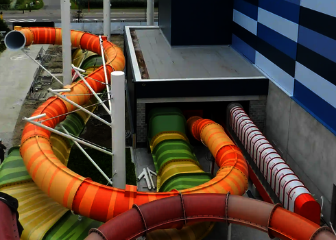 Bunte Wasserrutschen durchqueren seitlich die Wand eines modernen Bades.