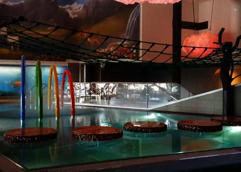 Modernes Hallenbad mit Kletterbereich, Holzplatzen und Wie-Spray Bauteilen.