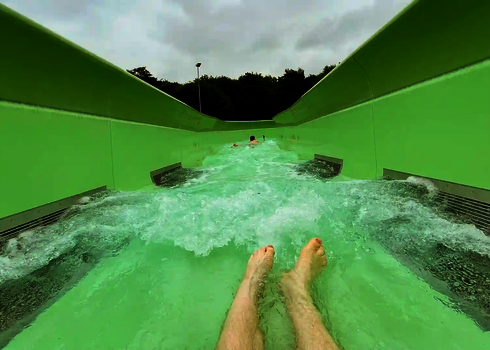 Füße im Vordergrund, Blick auf eine andere Person im Wildwasserfluss mit starker Strömung.