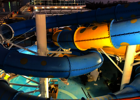 RR900-Rutschen in Blau und Gelb, teils transparent, auf einem Schiff bei Nacht.