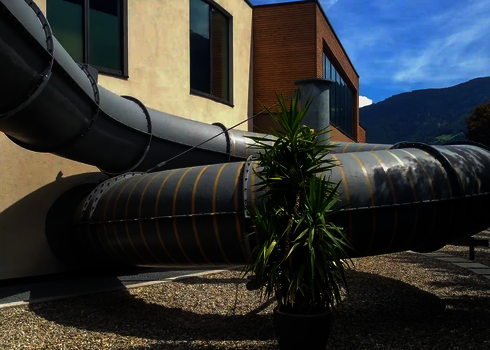 Blick auf eine schwarze Wasserrutsche außerhalb eines Gebäudes.