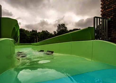 Startbereich des Wildwasserflusses mit ruhigem Wasser und angrenzender Backsteinfassade.