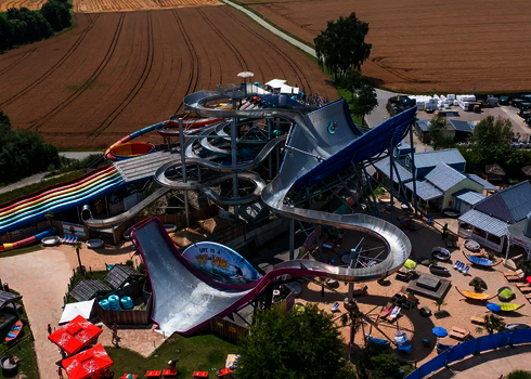 Luftaufnahme des Galaxy Erding mit gut sichtbarer pinker Sidewinder Wasserrutsche.