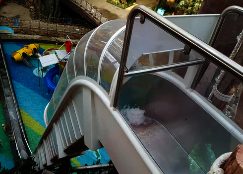 Startbereich der Freifallrutsche in einer Indoor-Anlage mit buntem Kinderbecken.