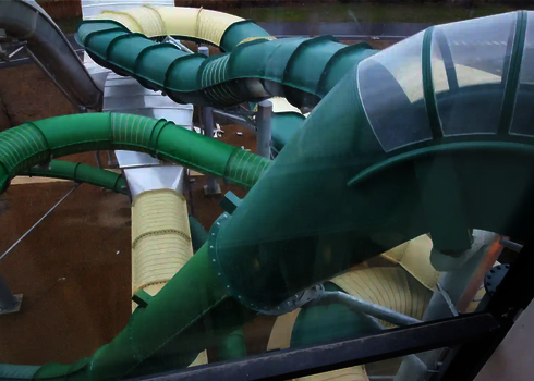 Ein dunkelgrüner Fallstart, der in eine grüne Röhrenrutsche übergeht.