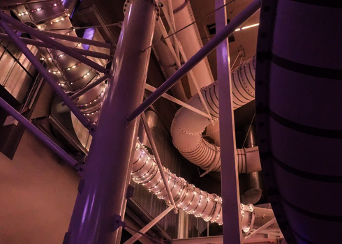 Verschlungene Rutschenstruktur mit weißen LED-Lichtern in Innenarchitektur.