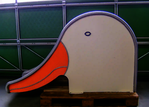  Kleine Kinderrutsche in Entenform mit oranger Rutschfläche, auf einer Palette.