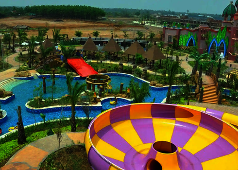 Wasserpark mit Schwimmbecken, ein schlossähnlichen Gebäude und einer bunten Raft Bowl.