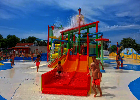 Bunter Kinderbereich mit spielenden Kindern in einem Wasserpark.