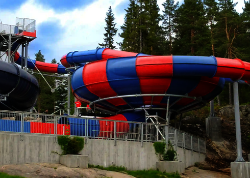 Rot-blaue Raft Bowl Rutsche vor wäldlichem Hintergrund.