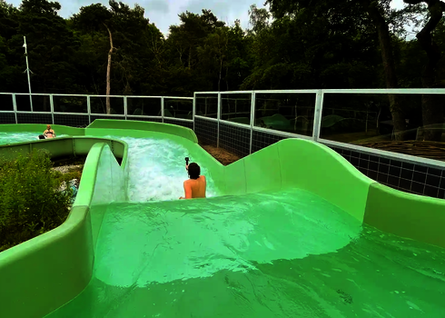 Ein Mann mit Kamera treibt auf dem Rücken durch eine Kurve des Wildwasserflusses.