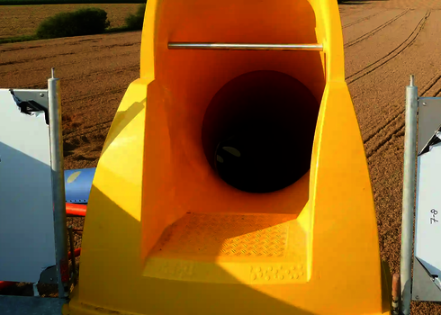 Nahaufnahme eines gelben Einstiegsbereichs zu einer Wasserrutsche mit Sicherheitsstange.
