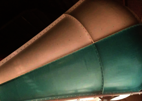 Hellblaues Element der Body Cone Wasserrutsche mit Schraubverbindungen an der Decke montiert.