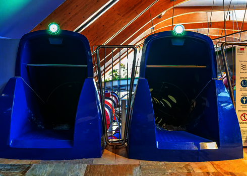 Zwei blaue Startbereiche mit grünen Sensorampeln und einer Hinweistafel in einer Schwimmhalle.