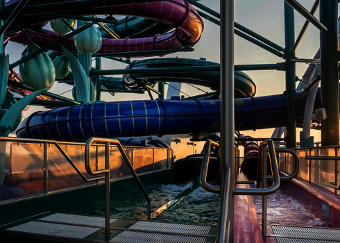 Blick auf zwei Wasserrutschen-Auslaufbecken bei Sonnenuntergang auf einem Kreuzfahrtschiff.
