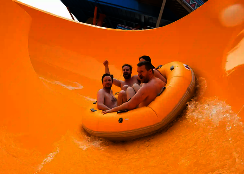 Vier Erwachsene fahren gemeinsam im gelben Rundreifen durch den gelben Trichter der RR2700.