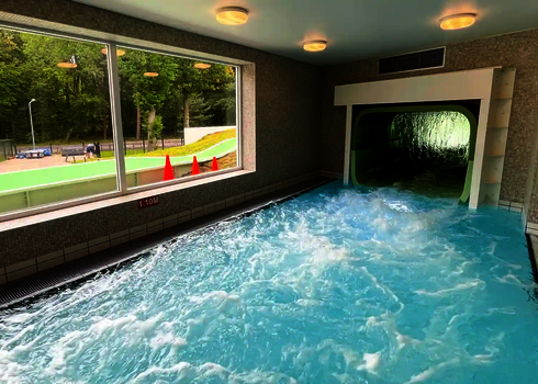 Blick auf den Innenbereich mit dem Auslauf des Wildwasserflusses und sprudelndem Wasser.