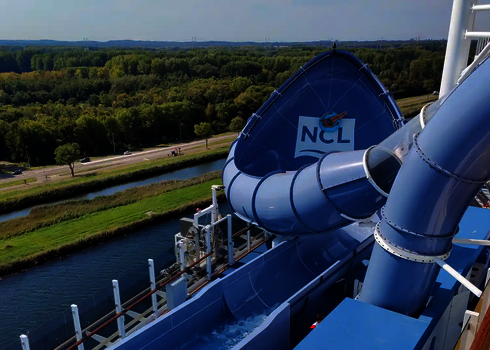 Seitlicher Blick auf die blaue Lotus Reifenrutsche mit NCL-Logo auf hoher See.
