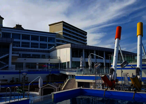 Wasserpark mit gelben und roten Cannonball vor blauer Kulisse.