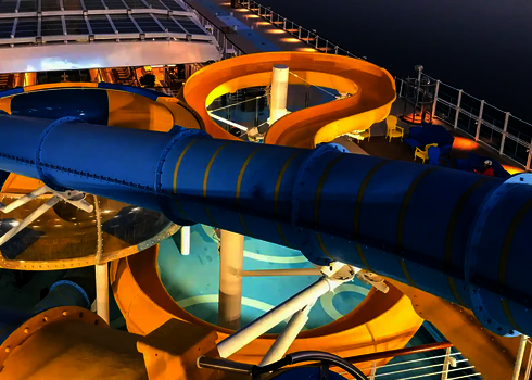 Blaue RR900 Wasserrutsche vor einer gelben offenen Rutsche, die in eine Body Bowl übergeht.