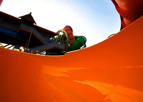 Bunter Treppenturm und die verschlungenen Rutschen der Reifenrutsche RR2700 aus Bodenperspektive.