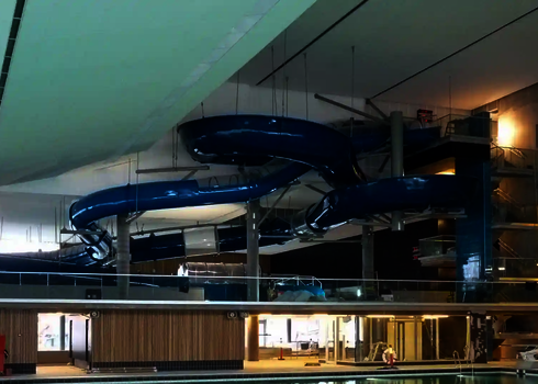 Eine blaue RR1200 Wasserrutsche in einem Hallenbad.