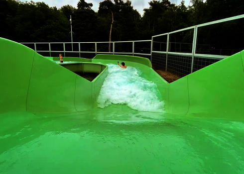 Blick auf eine abfallende Passage mit starker Strömung im grünen Wildwasserfluss.