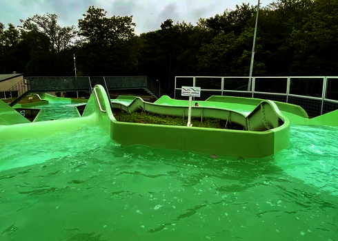 Blick auf eine Wasserbeckenfläche mit Mittelinsel und Abzweigung im Wildwasserfluss.