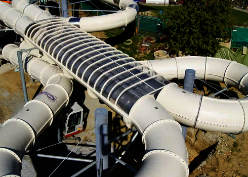 Blick von oben auf eine weiße Raft Racer Wasserrutsche in Herzform.