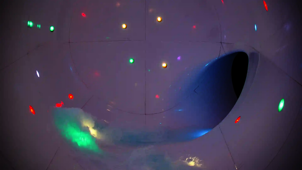 Farbige LED-Lichter in einer weißen Röhre mit Wasserströmung zur Öffnung.