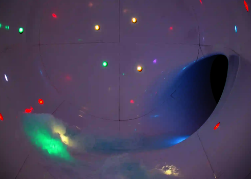 Farbige LED-Lichter in einer weißen Röhre mit Wasserströmung zur Öffnung.