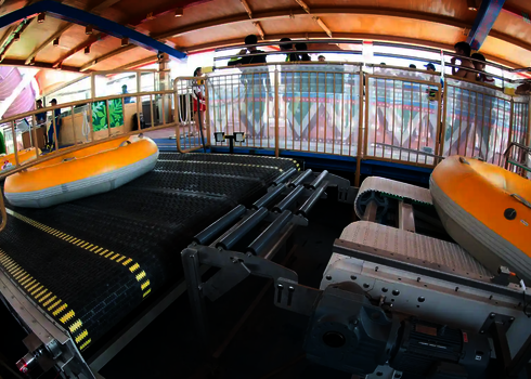A yellow slide raft is centered on the upper transfer point of the tire lift system.