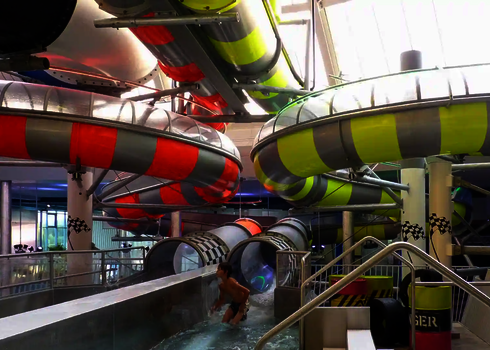 Junge Person verlässt das Auslaufbecken der Body Racer Rutsche mit Wasserstrom.