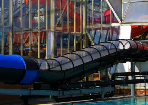 Der schwarze Speed Blaster mit transparentem Dach führt vom Gebäude in ein Außenbecken.