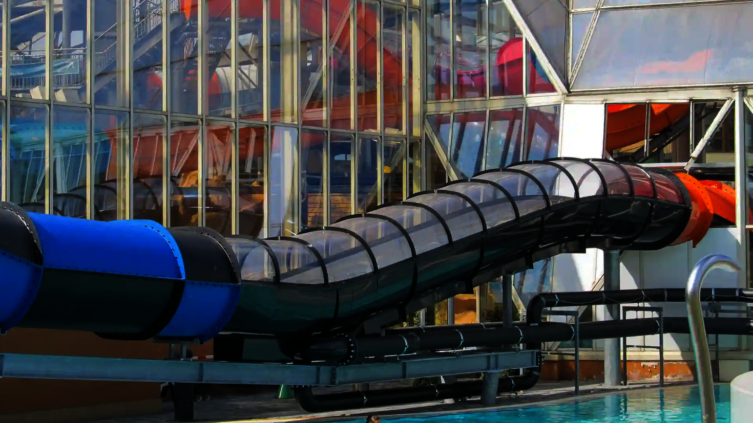 Der schwarze Speed Blaster mit transparentem Dach führt vom Gebäude in ein Außenbecken.